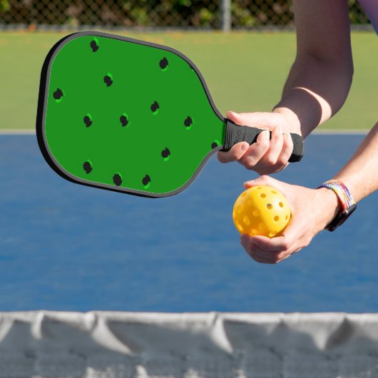 Zwarte kleine gaten op groen pickleball paddle (Insitu)