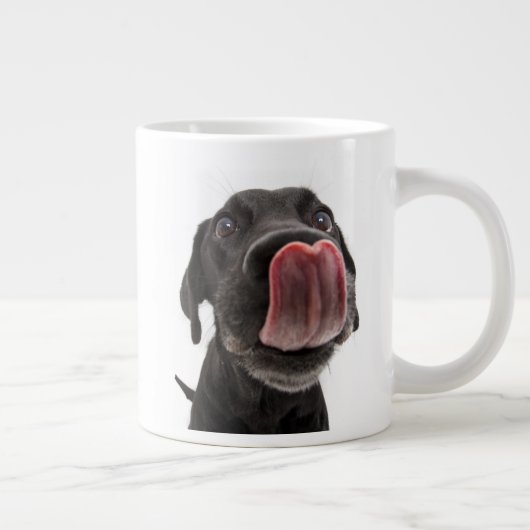 Zwarte labrador die zijn neus slaat grote koffiekop (Rechts)