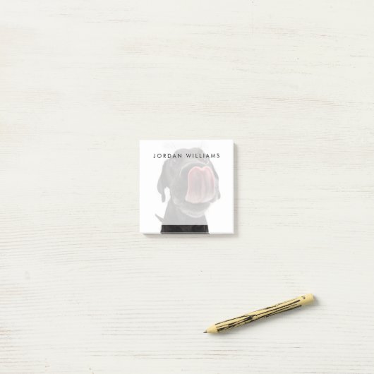 Zwarte labrador die zijn neus slaat post-it® notes (Op bureau)