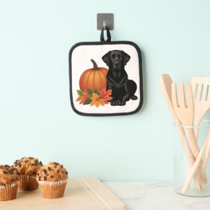 Zwarte labrador met herfstbladeren en pompoen pannenlap