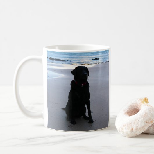 Zwarte labrador op een strand koffiemok (Met donut)