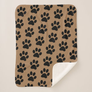zwarte pootafdrukken op bruin sherpa deken