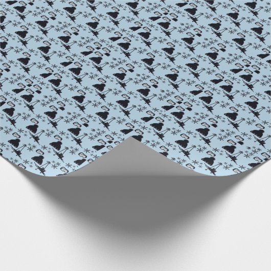 Zwarte ski-uitrusting & sneeuwvlokken op blauw cadeaupapier (Hoek)