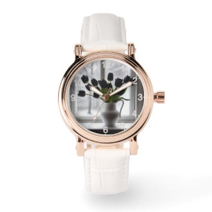 Zwarte tulpen in witte vaas naast bevroren raam, horloge