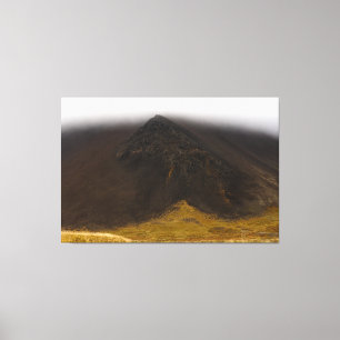 Zwarte vulkanische berg en lage wolken canvas kuns afdruk