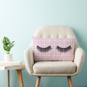 Zwarte wimpers op roze plaid kussen