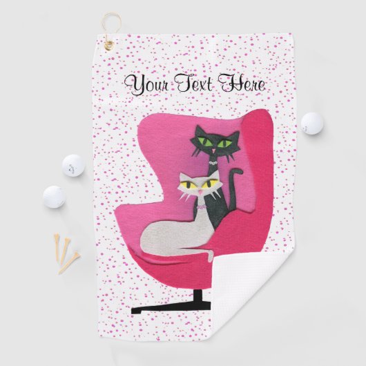 Zwarte witte atoomkatten zittend in een stoel roze golfhanddoek (Insitu)
