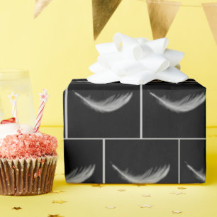 Zwevend wit veertje op zwart cadeaupapier